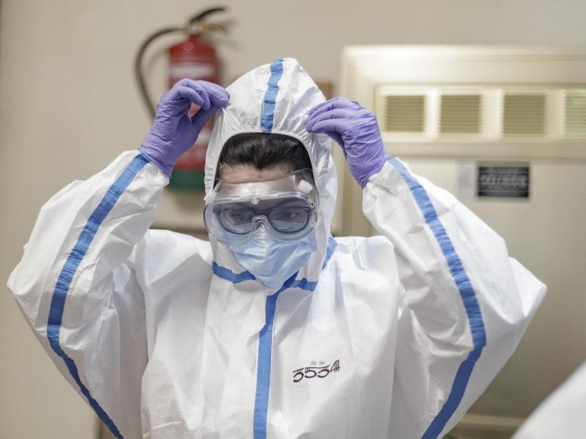Una sanitaria poniéndose el equipo de protección contra la Covid en 2020.