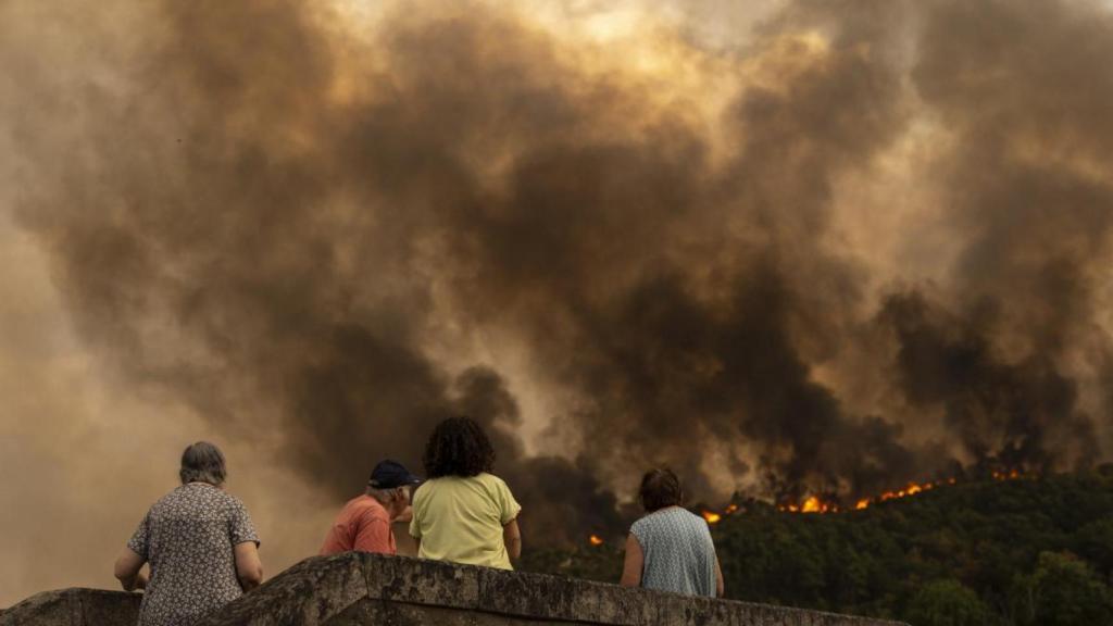 Varias personas observan un incendio en Orense