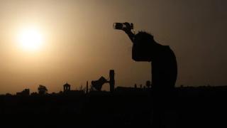Una persona se refresca al atardecer en una jornada de altas temperaturas en la ciudad de Córdoba.