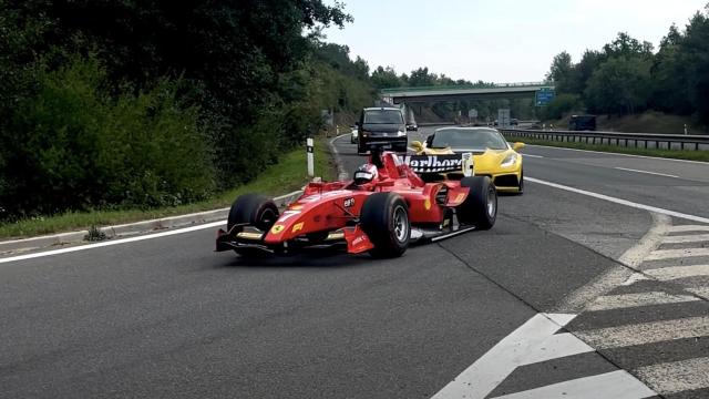 El monoplaza circulando por la carretera escoltado por deportivos