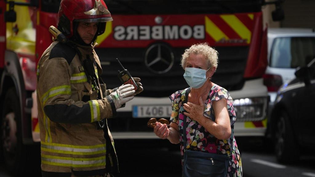 Un bombero atiende a una mujer durante un incendio. Eduardo Manzana / Europa Press
