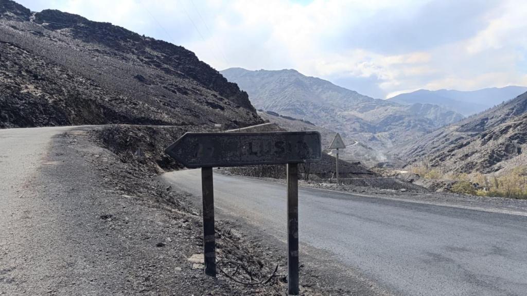 El cartel que indica la entrada a Lusío, abrasado por las llamas.