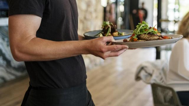 Un camarero sirviendo platos.