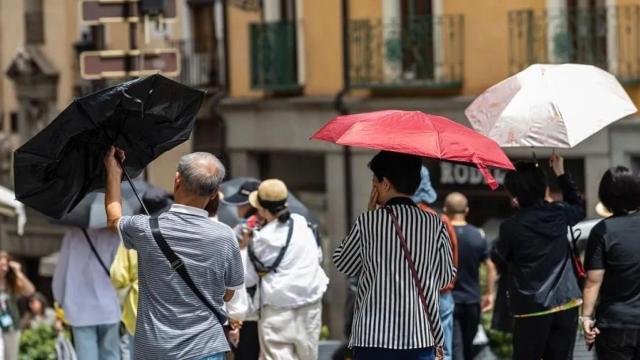 Turistas se protegen del sol en la ciudad de Toledo.