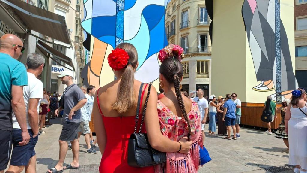 Claudia y Úrsula ante la portada de la Feria de Málaga en calle Larios.