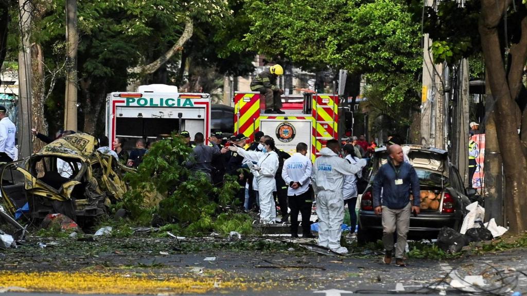 Fuerzas de seguridad y forenses trabajan junto a los escombros en la base aérea Marco Fidel Suárez, en Cali.