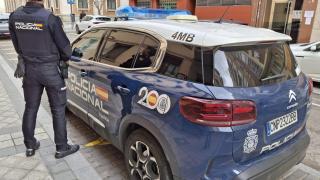 Un agente de la Policía Nacional de Valladolid junto a un vehículo oficial