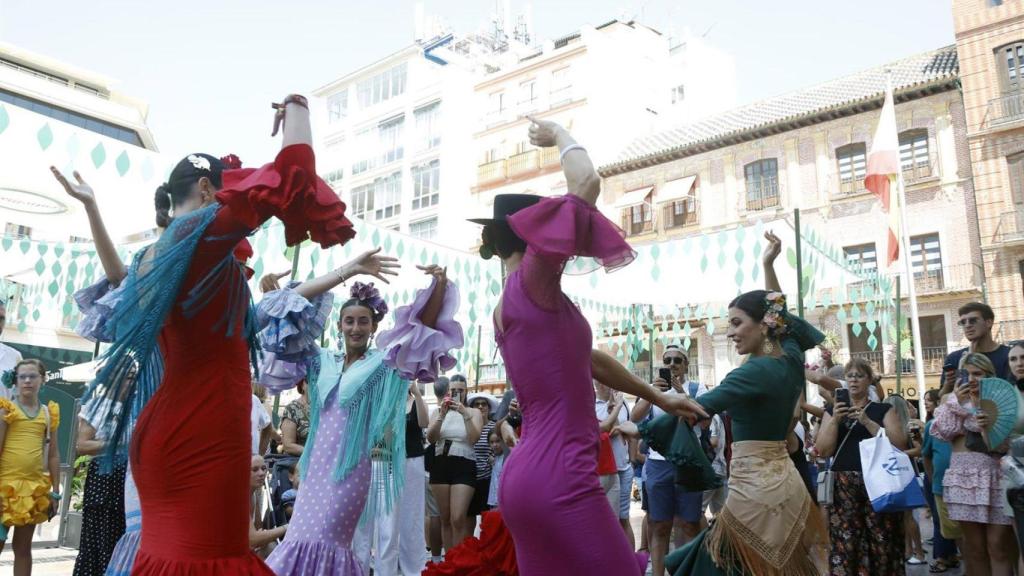 Mujeres vestidas con el traje típico, bailan y disfrutan de la Feria del centro de Málaga.