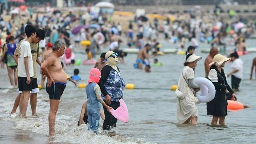 Una mujer y un niño en la playa usando 'facekinis'.