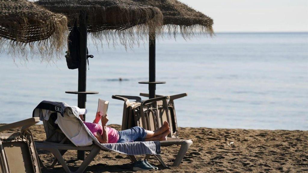 Un señor tomando el sol en la playa. Imagen de archivo.
