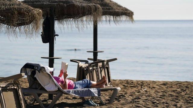 Un señor tomando el sol en la playa. Imagen de archivo.