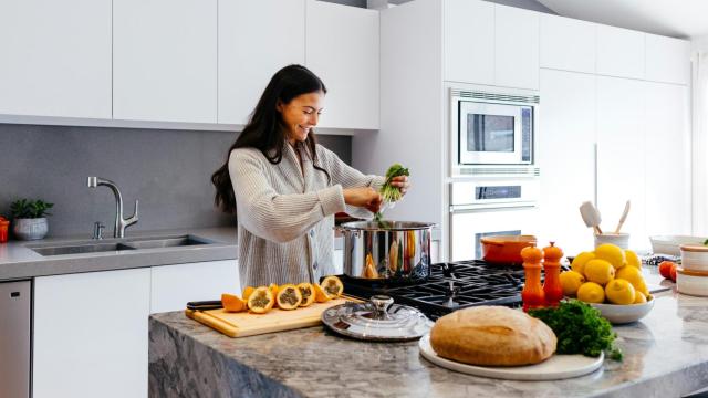 Imagen de archivo de una chica cocinando en casa empleando frutas y verduras.