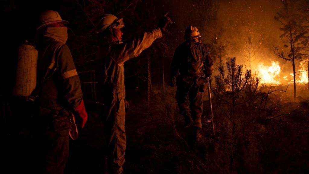 Un grupo de bomberos forestales tratan de extinguir el fuego, este viernes, en Argayo (León).