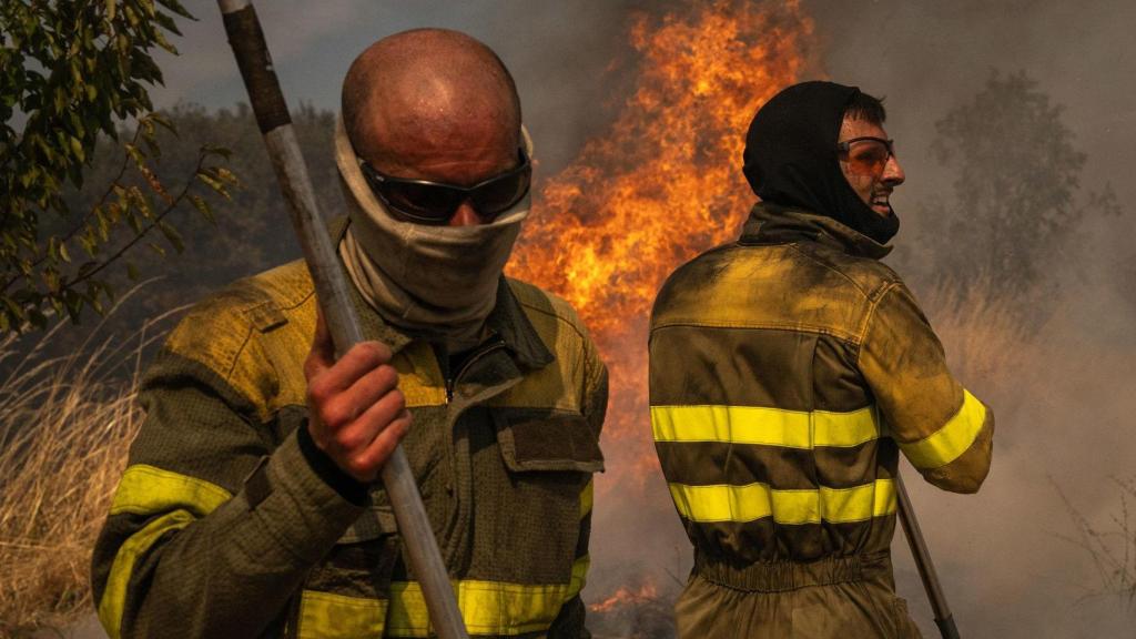 Dos voluntarios realizan labores de extinción en el incendio de Oímbra, Orense.