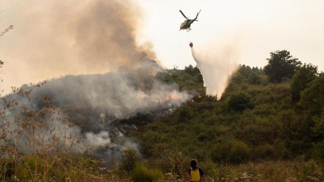 Un helicóptero trabaja en las tareas de extinción del incendio en Molinaseca, León.