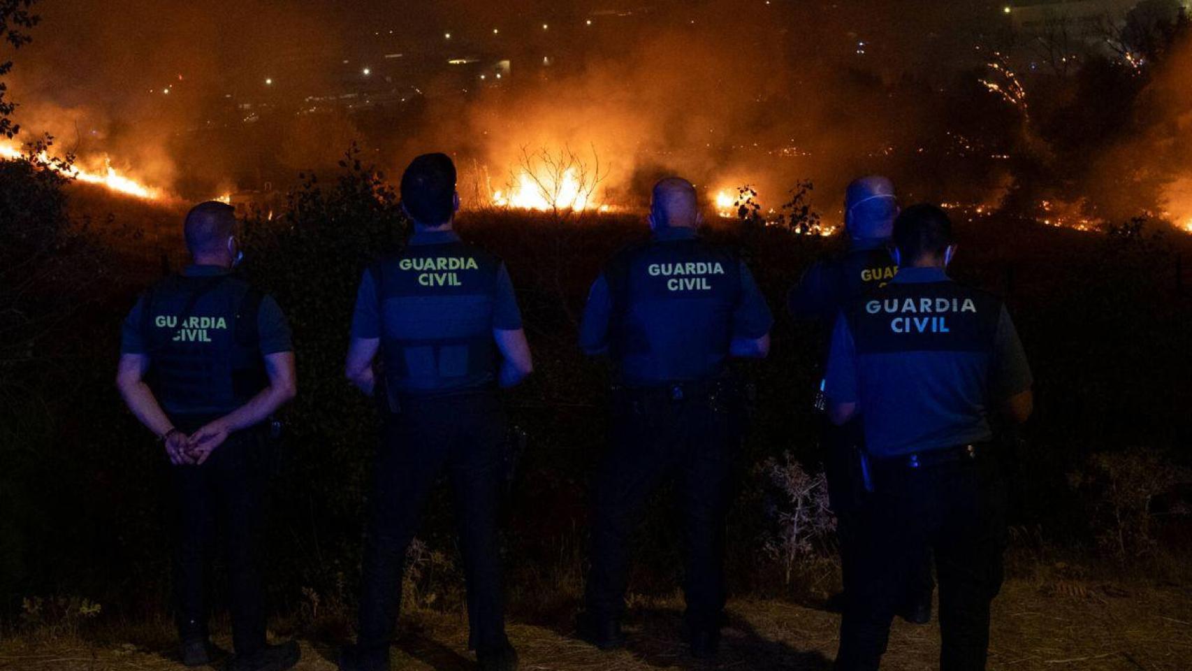 Agentes de la Guardia Civil frente a un incendio forestal.