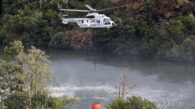 Un helicóptero colabora en las labores de extinción del incendio, a 19 de agosto de 2025, en Quiroga, Lugo.