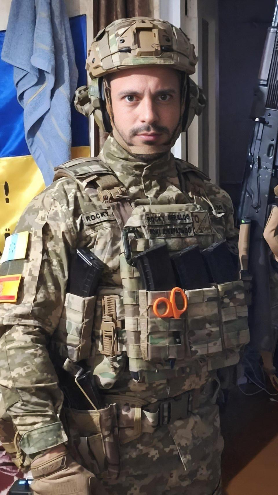 Geraldo posa en Ucrania con un AK-74 en la mano , la bandera de Canarias —con siete estrellas verdes, vinculada a movimientos nacionalistas— y la rojigualda española.