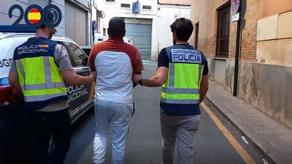 Agentes de la Policía Nacional con la persona detenida.