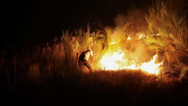 Un hombre trata de contener el fuego en Troncoso (Portugal), este agosto.