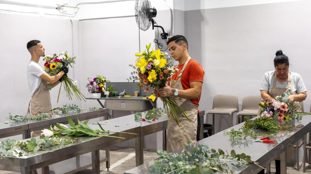 Laura Hernández, junto a sus compañeros, en su puesto de trabajo en Flores Solidarias.