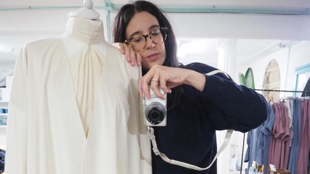 Isabel posa en su taller con un diseño de novia.