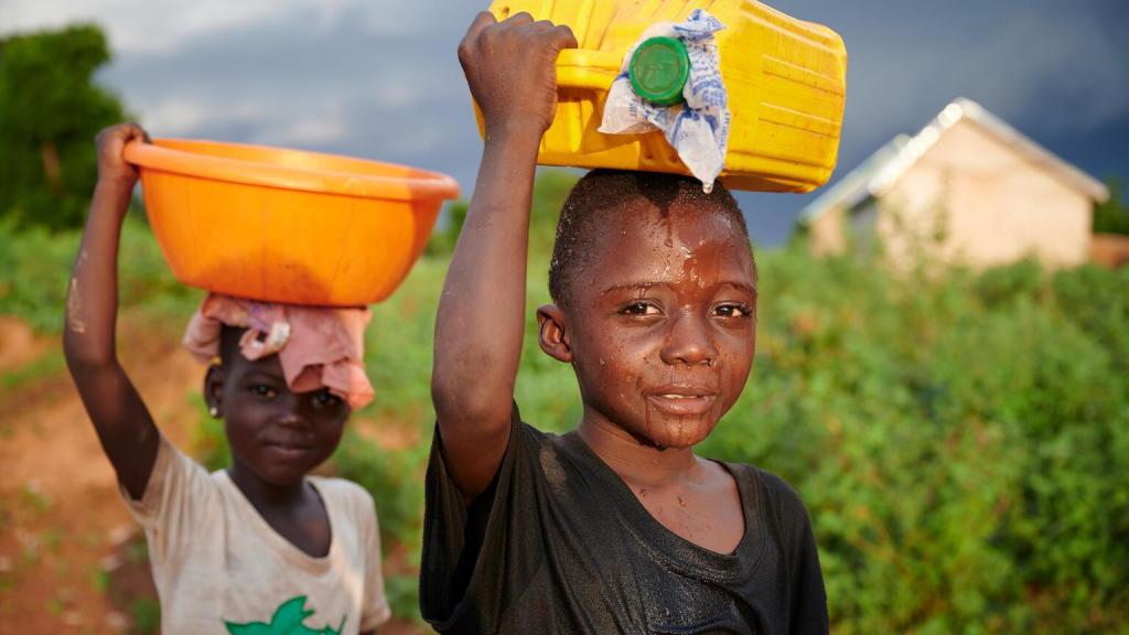 Dos niños transportan agua potable en Gana.