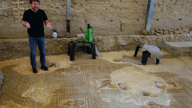 El arqueólogo municipal de Écija (Sevilla), Sergio García-Dils, junto al nuevo mosaico de 27 metros cuadrados hallado en el centro de la ciudad. Foto: José Manuel Vidal / EFE