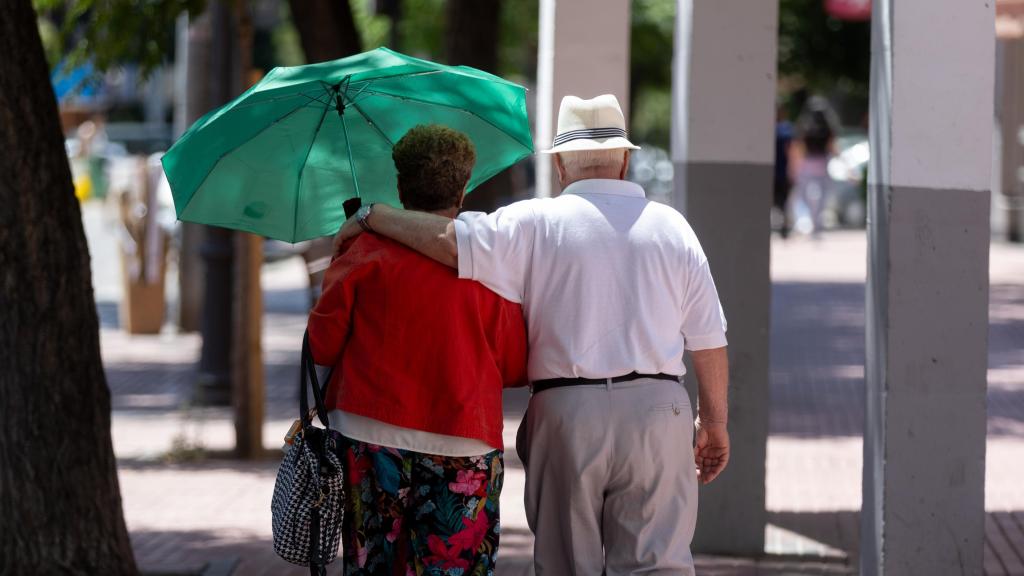 Dos personas mayores pasean en Madrid.