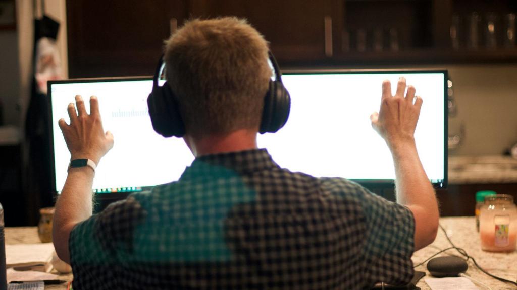 Una persona con auriculares usando un ordenador