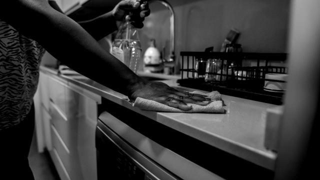 Una empleada de hogar limpia la encimera de la cocina