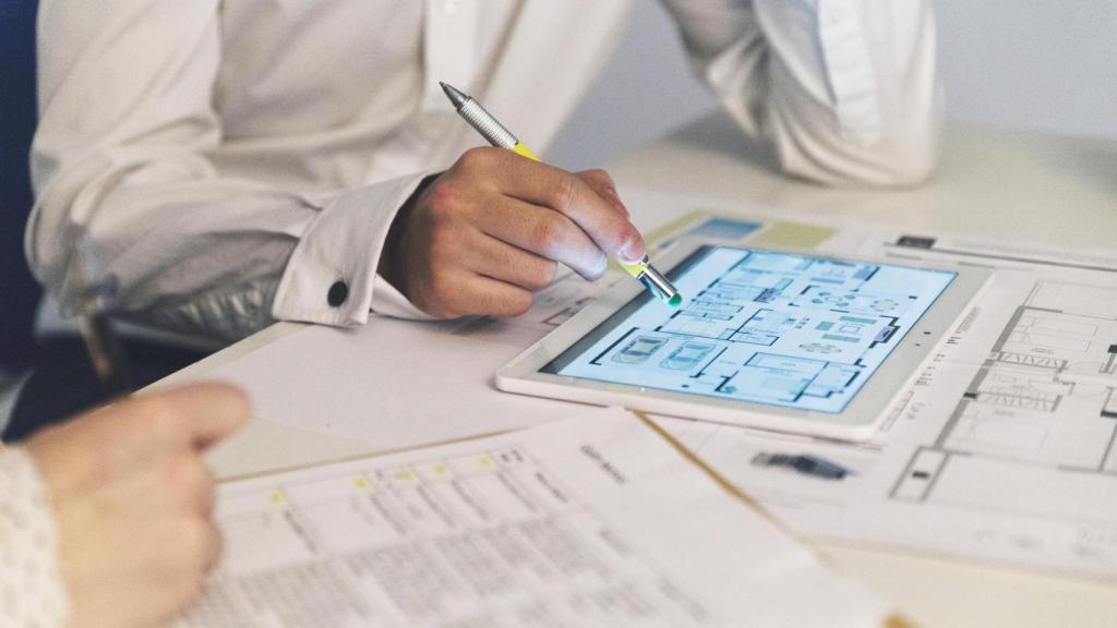 Profesionales verificando los planos de un edificio en una tableta.