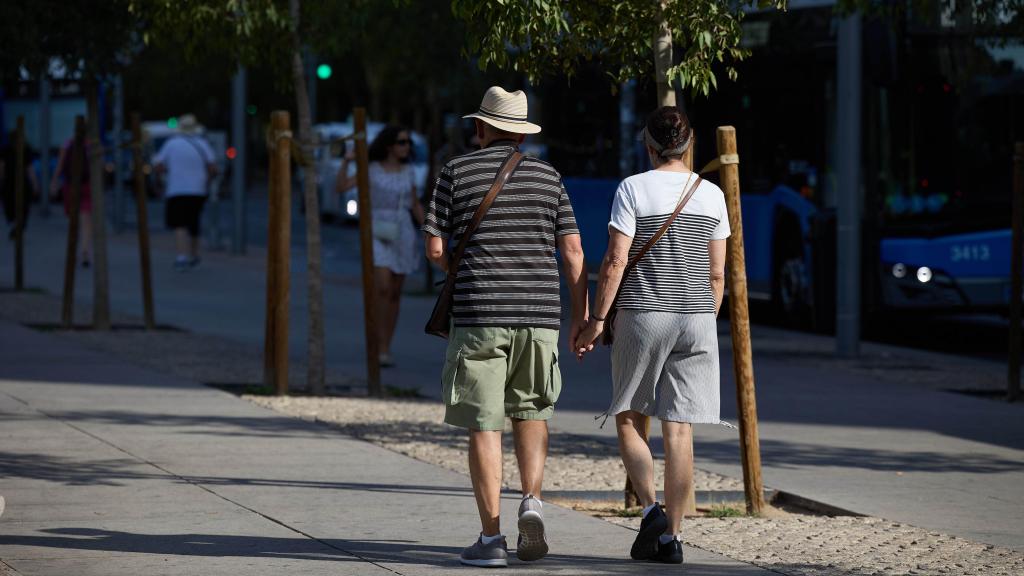 Una pareja de personas mayores dando un paseo por Madrid.