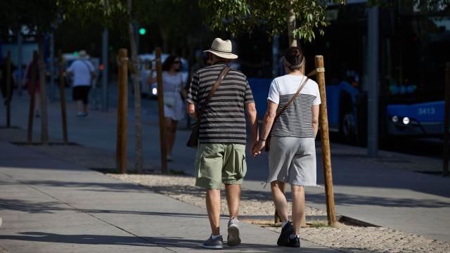 Una pareja de personas mayores dando un paseo por Madrid.