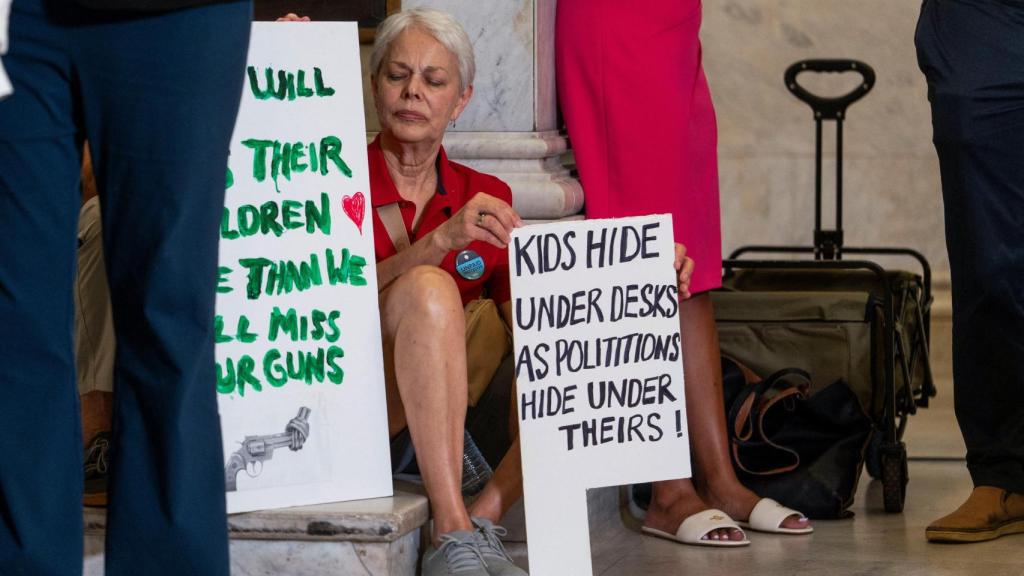Una activista sostiene un cartel condenando la falta de acción política para incrementar el control de armas tras el tiroteo en Minneapolis.