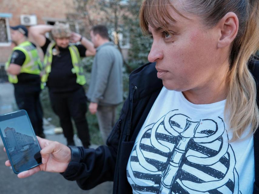 Olena muestra en la pantalla de su móvil el edificio donde vivía con sus hijas antes del bombardeo que arrancó de cuajo sus ventanas en julio.