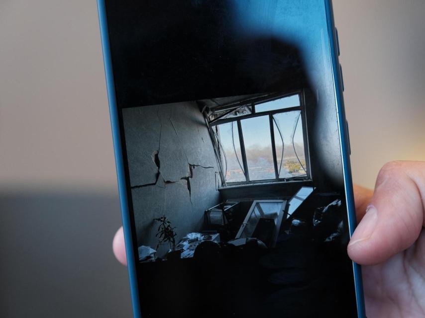 Olena muestra en la pantalla de su móvil una foto de cómo quedó su salón tras el bombardeo ruso que destruyó la última casa en la que había vivido.