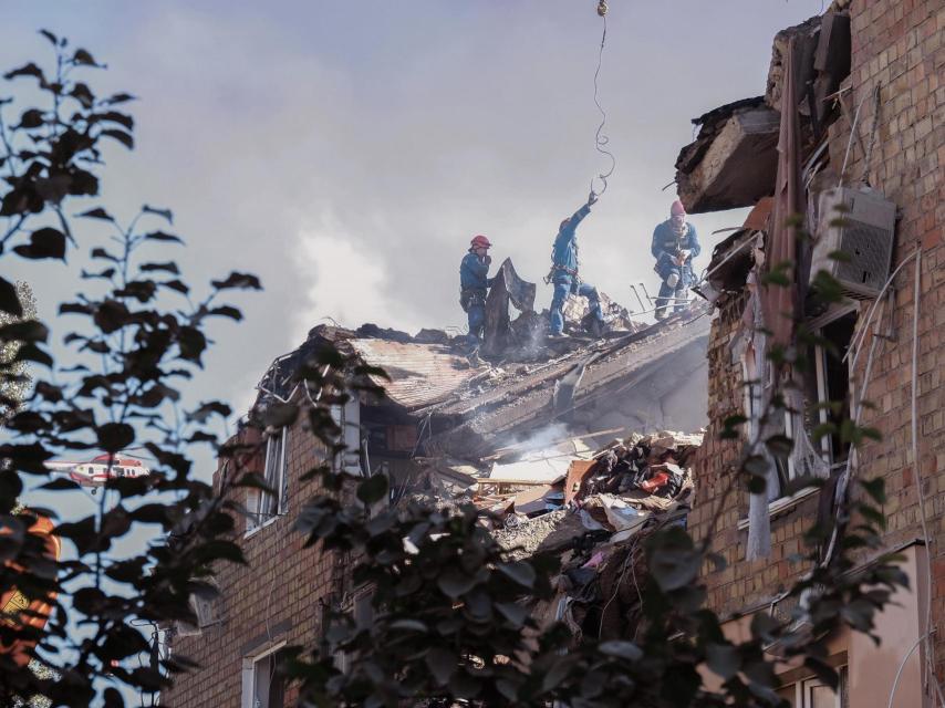 Rescatistas y bomberos trabajan en uno de los edificios residenciales bombardeados por Rusia, en Kiev.