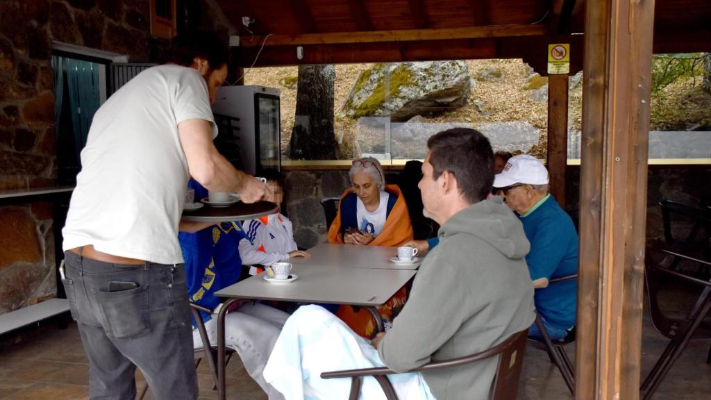 Ángel sirve a unos clientes en el chiringuito, a los pies del Lago de Sanabria