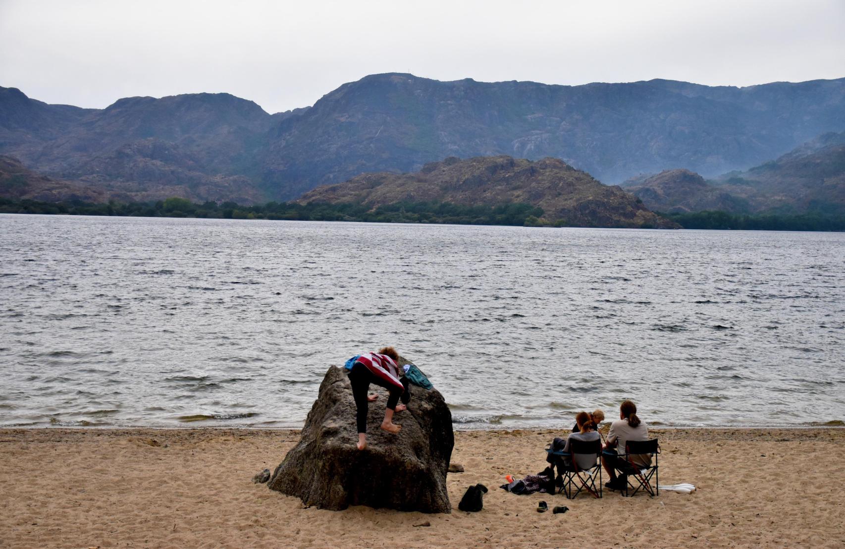 Unos visitantes disfrutan del Lago de Sanabria, que luce verde