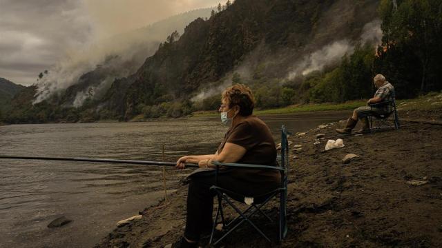 Una pareja pesca cerca el fuego.