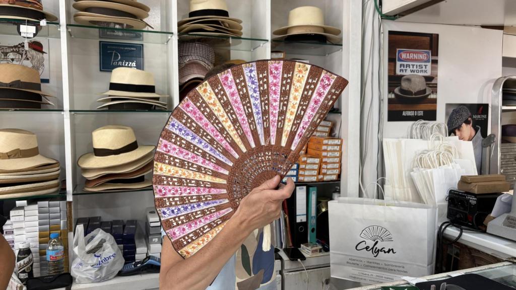 Cristina, la encargada de Celyan, tapándose la cara con un abanico.