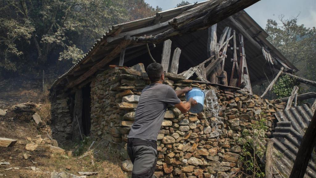 Ganadero propietario de algo más de cien vacas en Teixeira, intenta sofocar el fuego en uno de los refugios de los animales, a 10 de agosto de 2025, en Maceda, Ourense, Galicia (España).