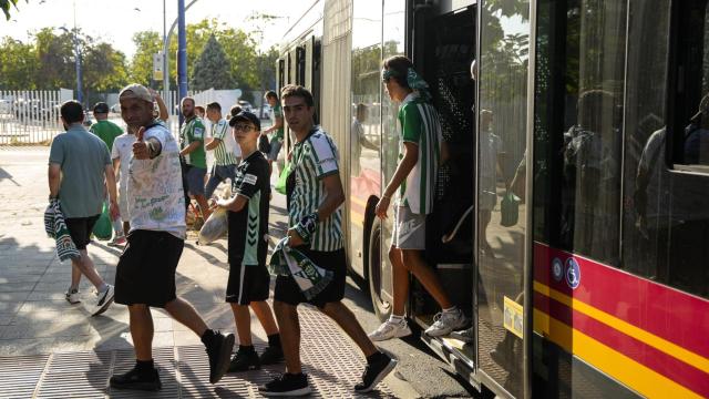 Aficionados del Betis se bajan del autobús en La Cartuja.