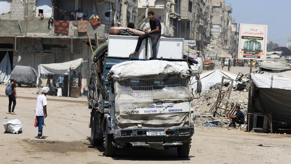 Palestinos desplazados viajan en un vehículo cargado con sus pertenencias, en la ciudad de Gaza.