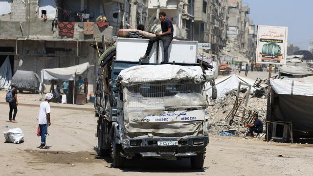 Palestinos desplazados viajan en un vehículo cargado con sus pertenencias, en la ciudad de Gaza.