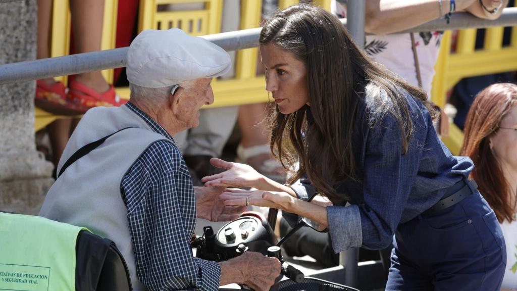 La reina Letizia charla con un vecino durante su visita a algunas de las zonas afectadas por los incendios en Extremadura.