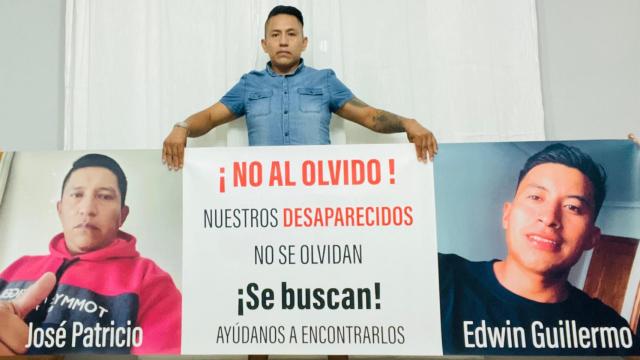 Daniel, hermano de José Patricio, posando con una pancarta con la imagen de su hermano y de Edwin Guillermo, ambos desaparecidos.