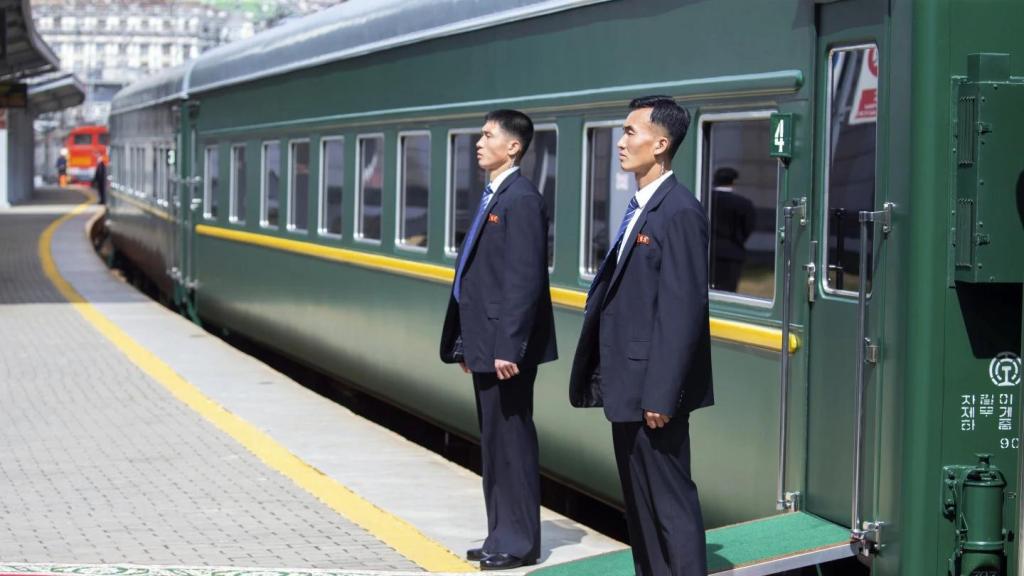 Dos agentes norcoreanos, en una de las puertas del tren 'Taeyangho'.