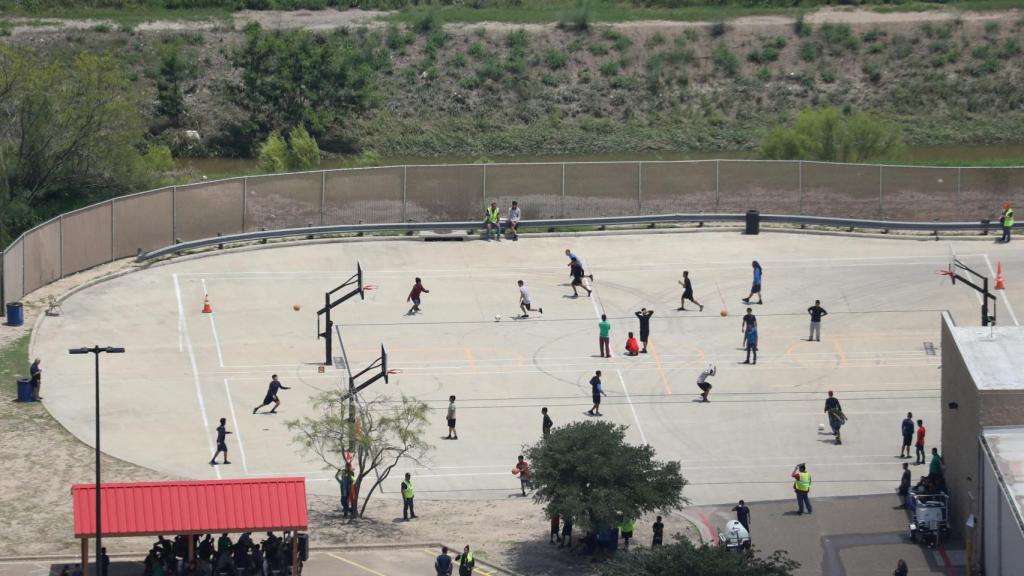 Niños guatemaltecos juegan en un centro de menores en Texas, EEUU.